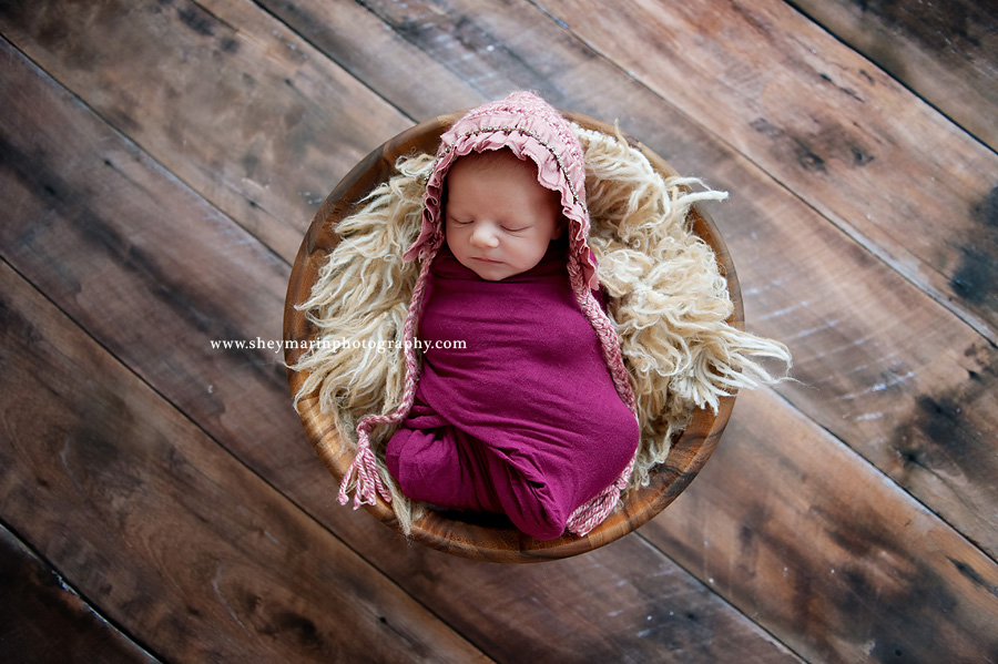newborn girl in basket and pink wrap