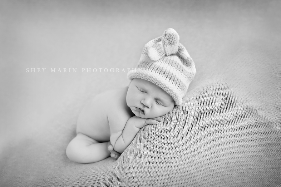 black and white photo of a newborn baby boy in a knit hat