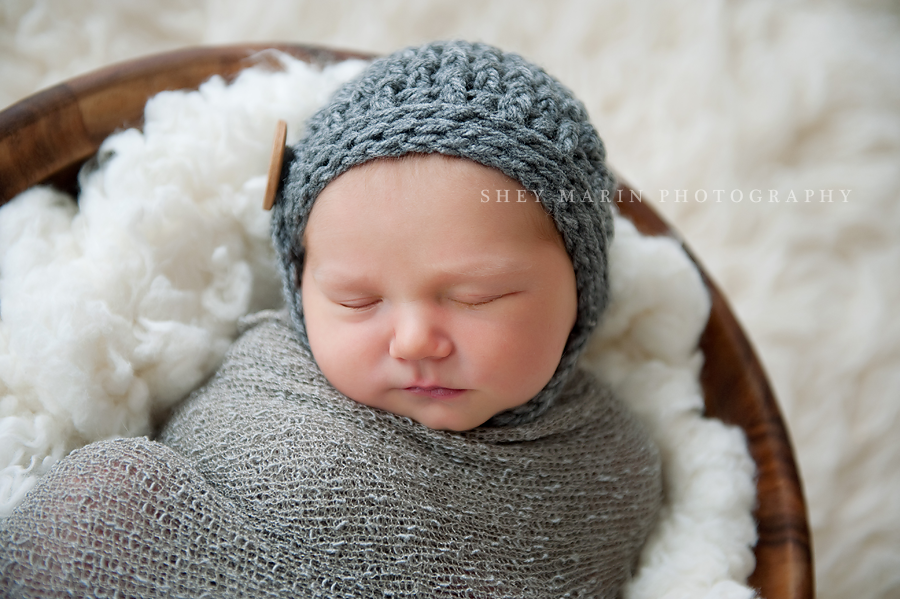 newborn baby boy in basket with grey hat