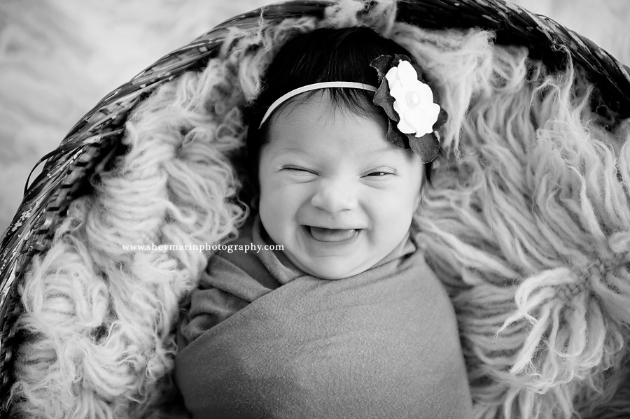 Black and white photo of newborn smiling