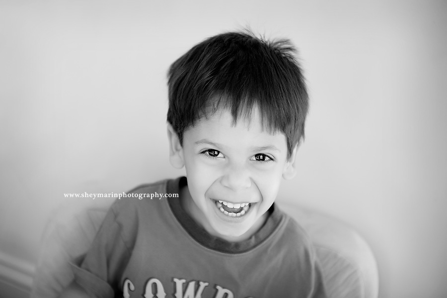 little boy smiling in black and white