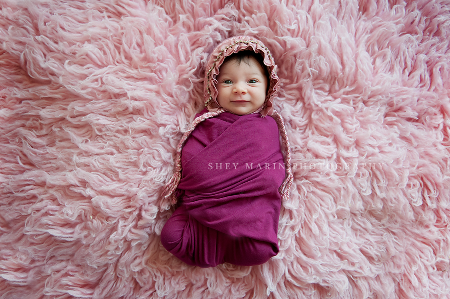 newborn girl on pink blanket