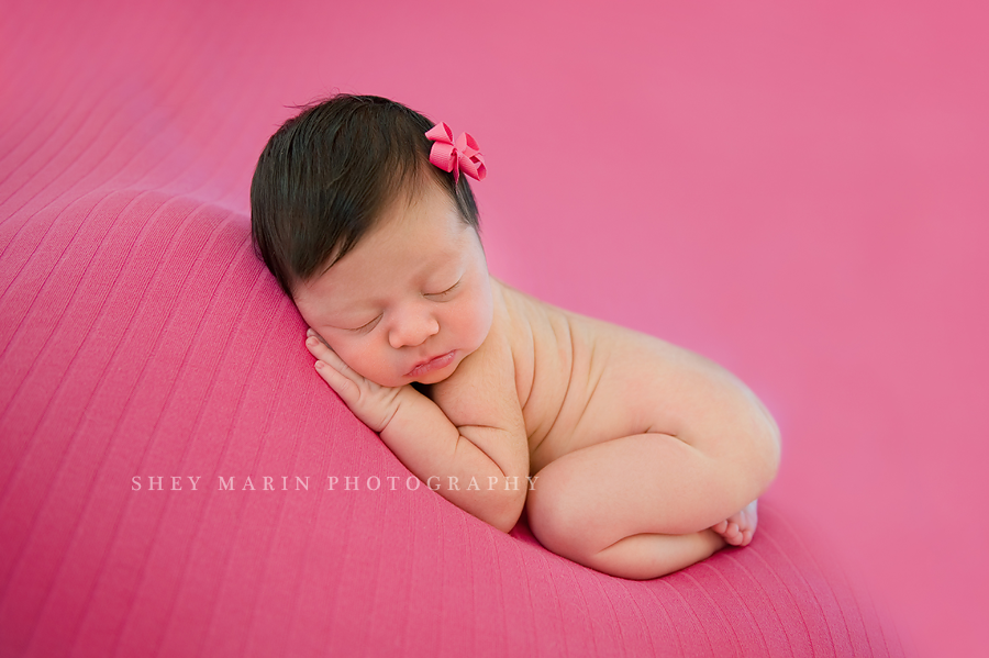 newborn baby girl on hot pink blanket