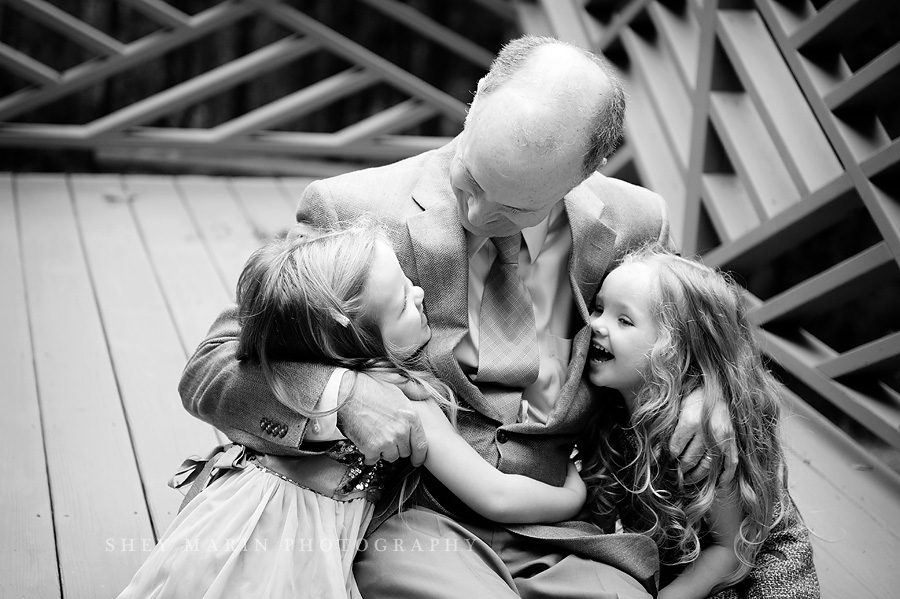 black and white photo of dad hugging his daughters