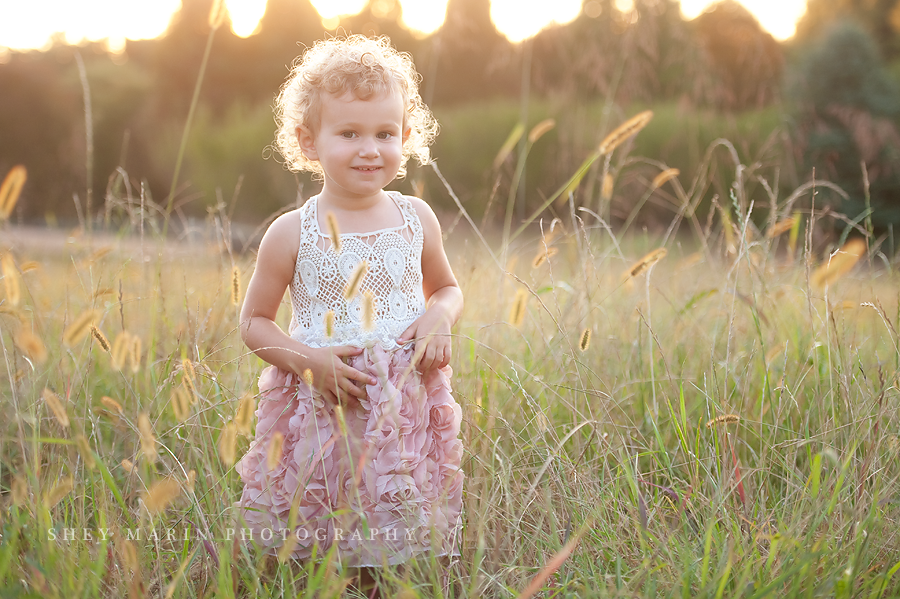 toddler girl at sunset in a field