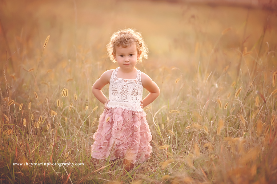 Little girl in a wheat field at sunset