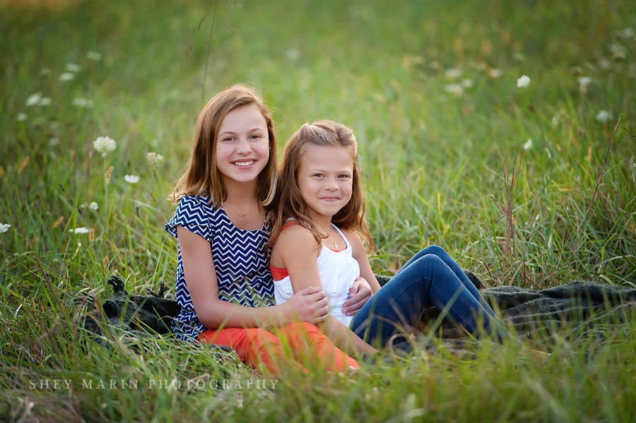 Two sisters smiling in the grass