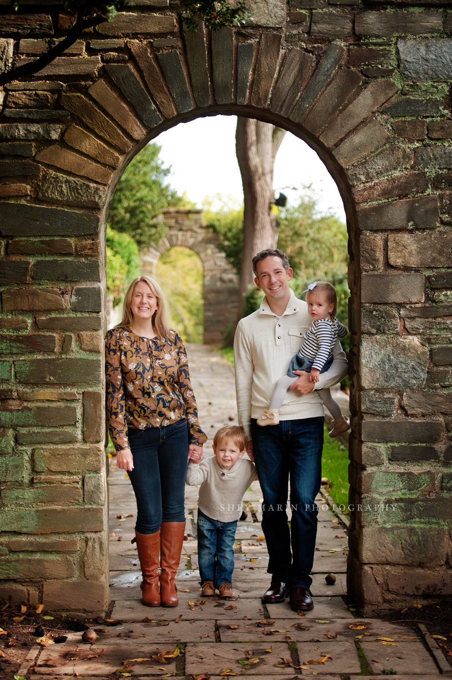 family standing in stone archway
