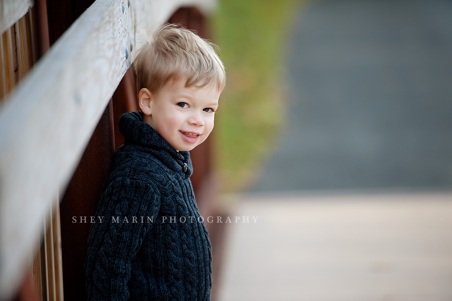 sweet little boy smiling on bridge in bethesda md