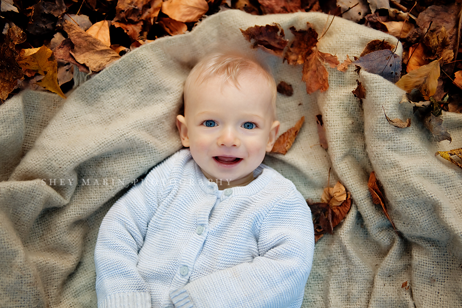cute baby boy smiling in fall leaves in washington dc