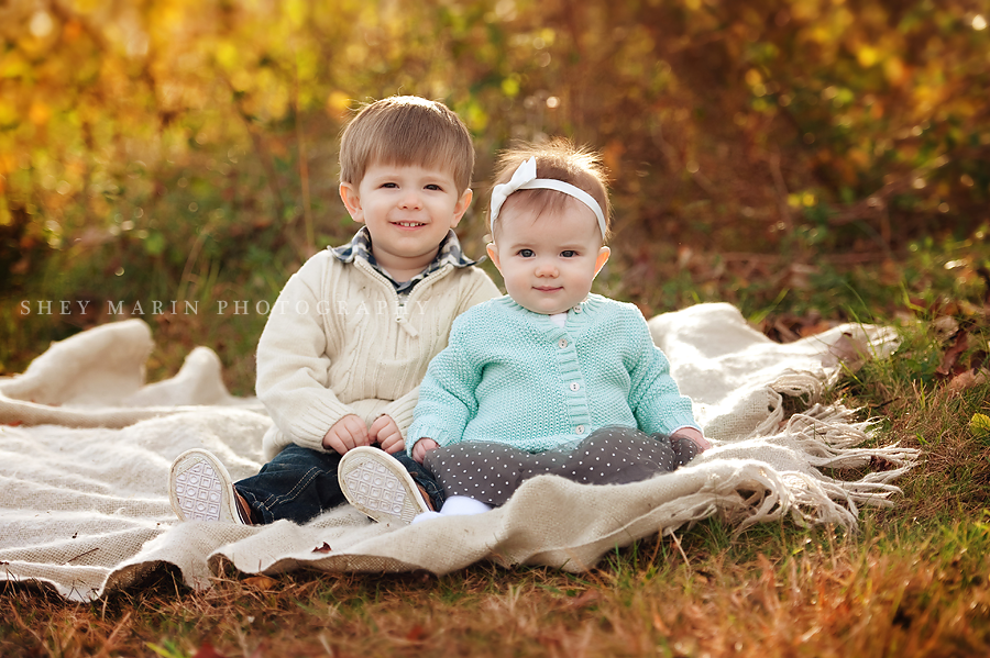 baby siblings on a blanket in fall