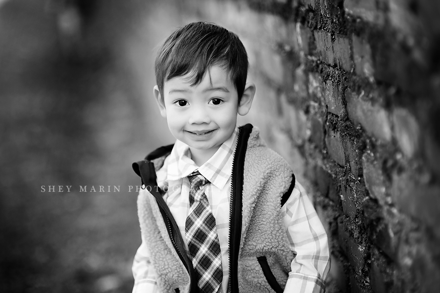 black and white photo of toddler in a vest