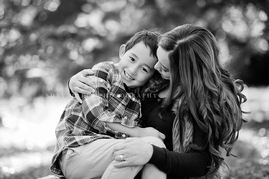 black and white photo of a little boy and his mother cuddling