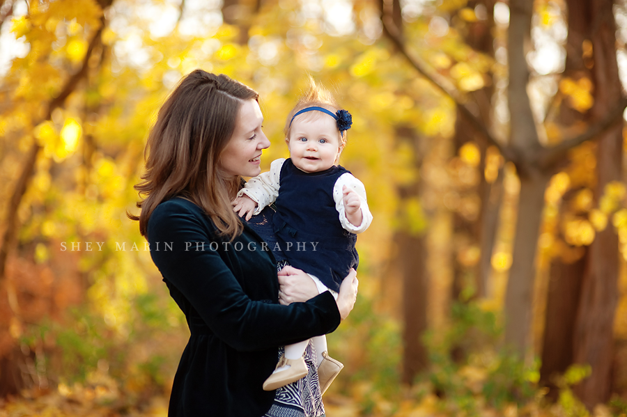 mom and baby in fall leaves