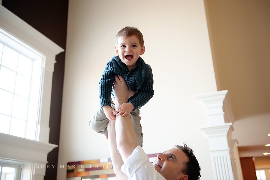little boy smiling in dad's arms in Maryland home