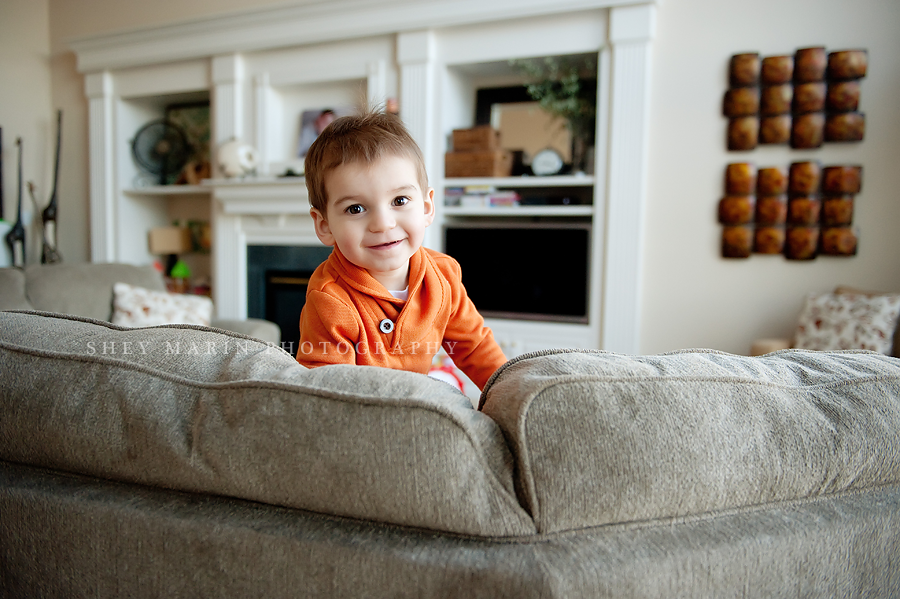 Little boy peeking over a couch in Frederick, MD