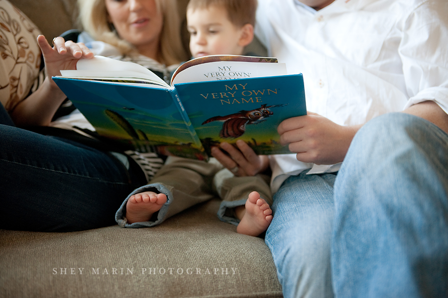 family reading to son on their couch