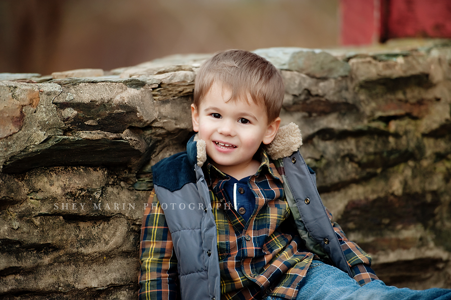 little boy leaning against stone wall in Frederick, MD