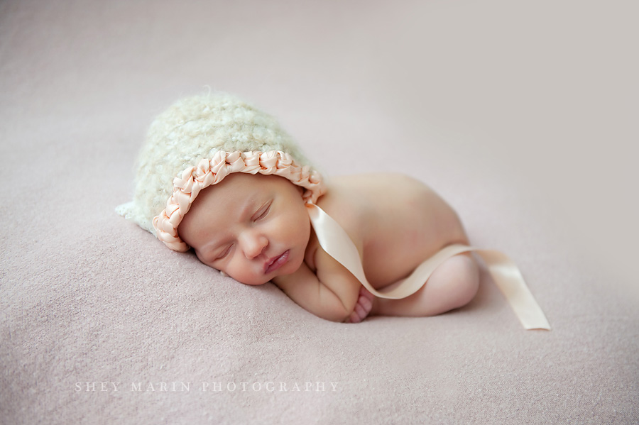 newborn baby girl in a pink bonnet