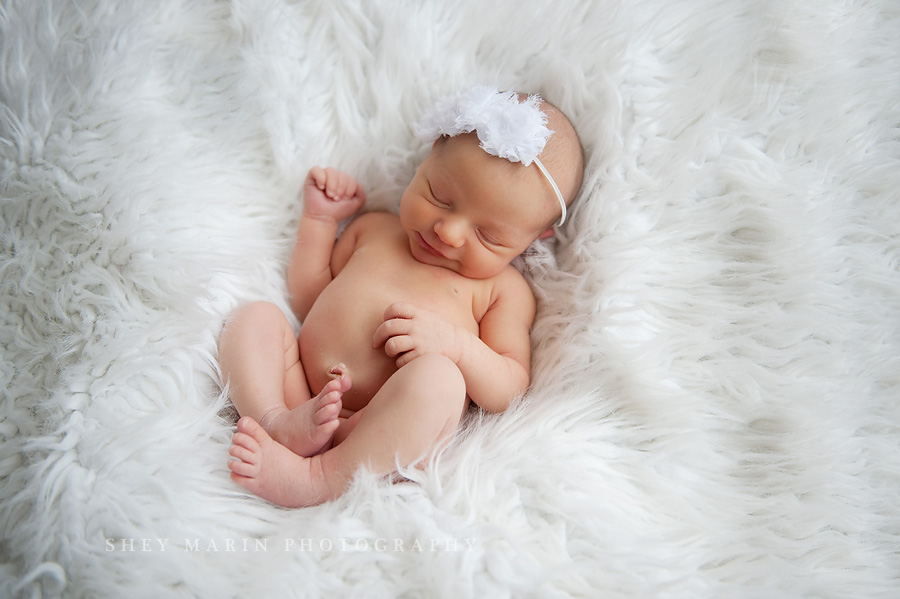 newborn baby girl on white fur