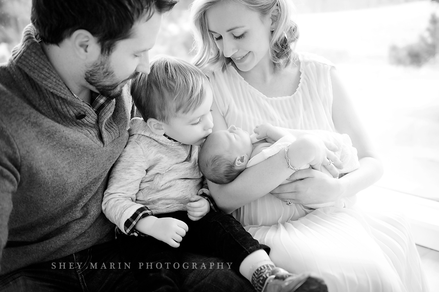 black and white candid photo of family and newborn
