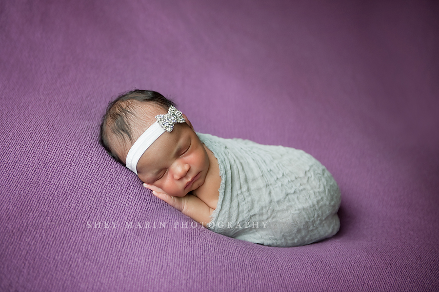 newborn baby girl on a purple blanket