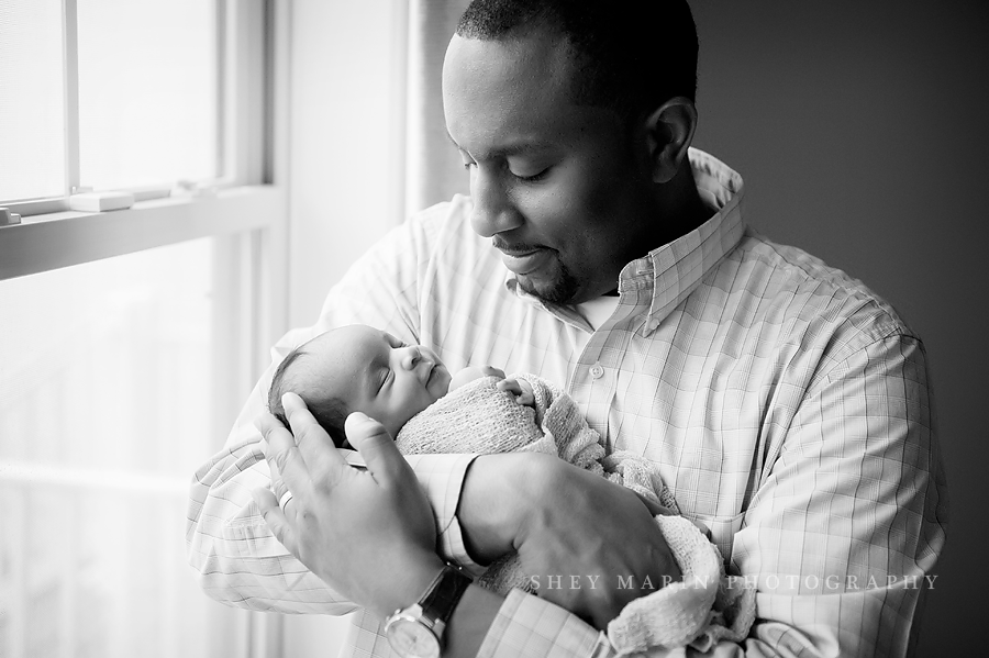black and white photo of father holding baby