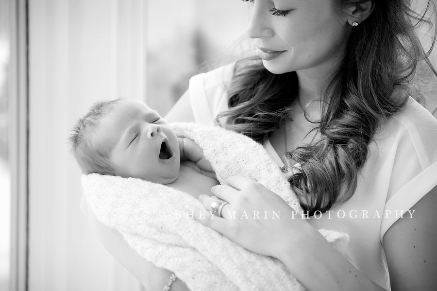 baby girl yawning in mother's arms