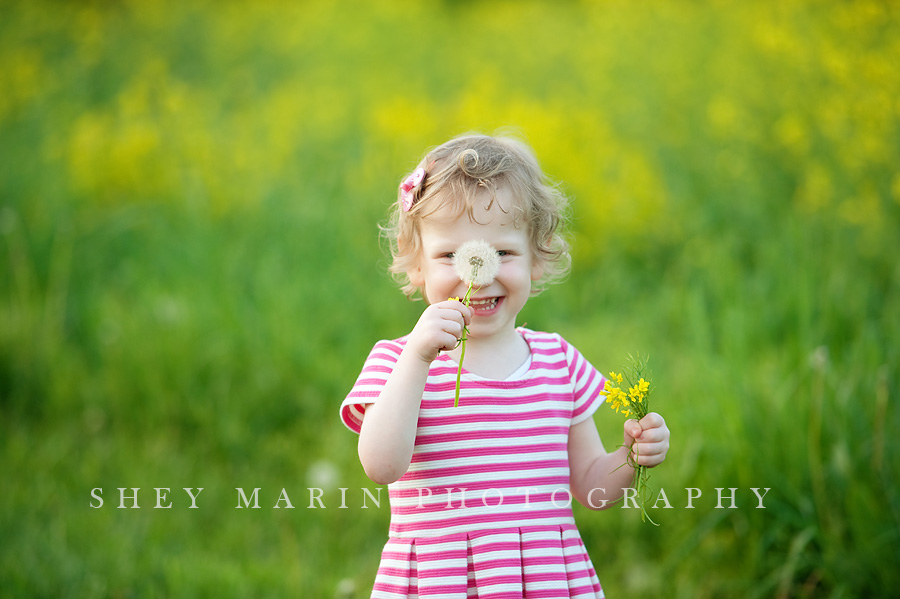 girl being silly with a dandelion flower