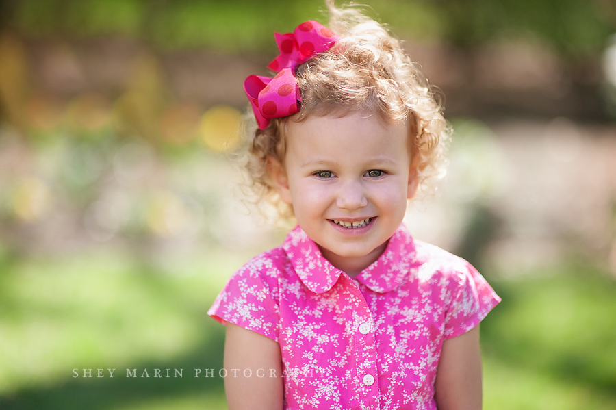 curly haired girl with pink bow