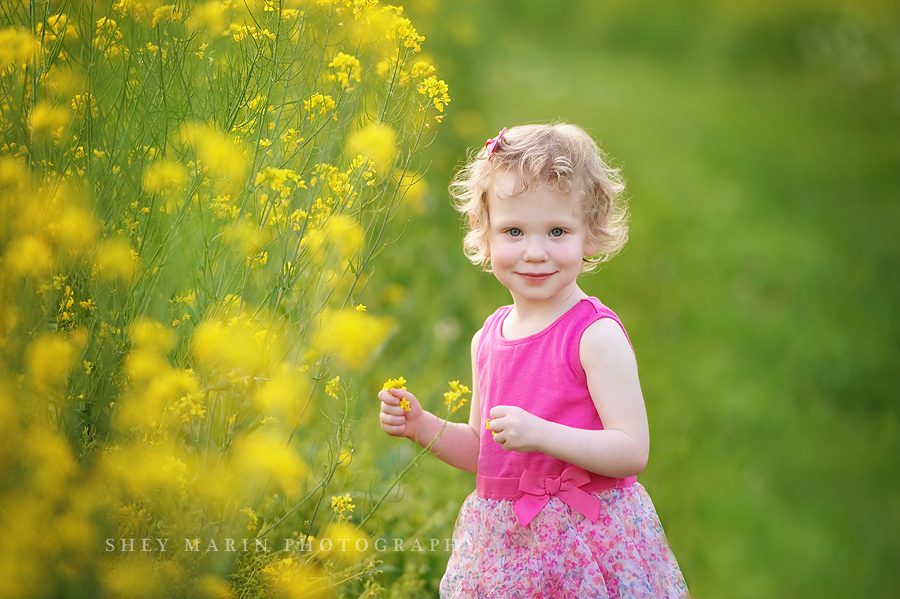 little girl in yellow wildflower field