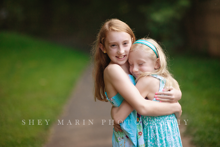 red head and blonde sisters hugging