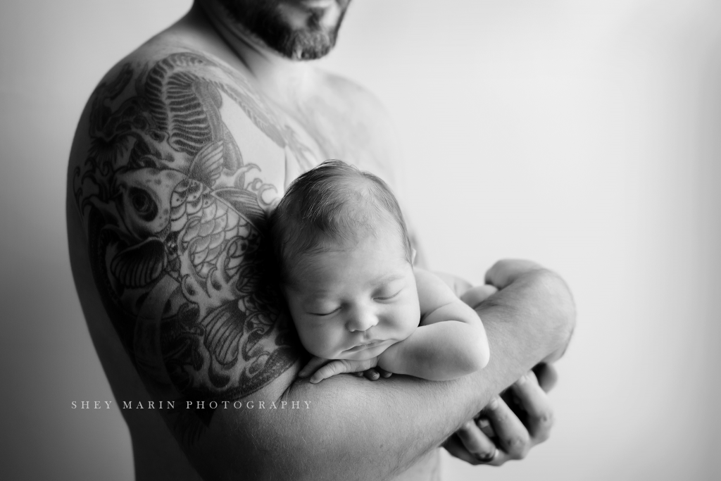 Frederick Maryland newborn baby photographer | nephew newborn baby held by dad with tattoo