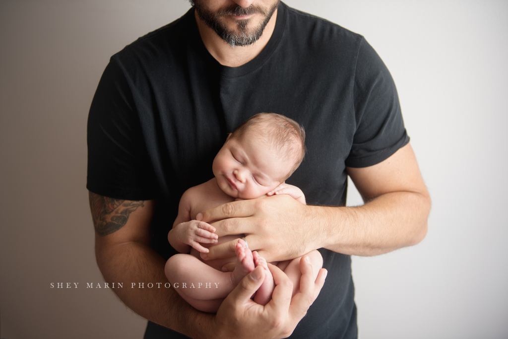 Frederick Maryland newborn baby photographer | nephew baby held in dad's arms