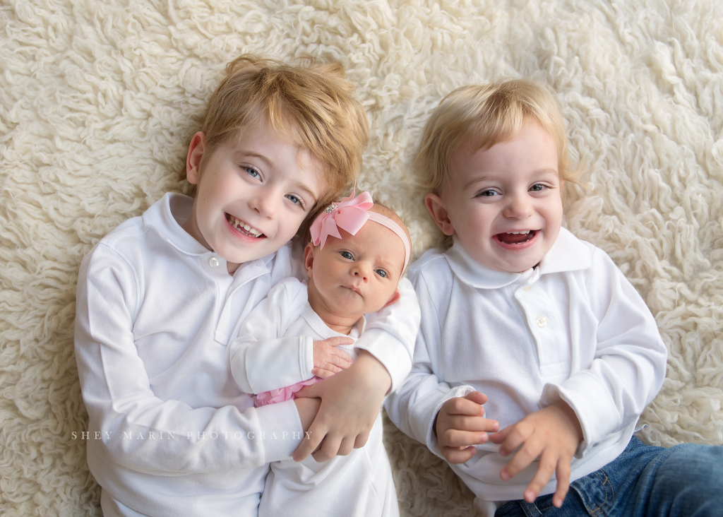 new baby girl photographed with big brothers