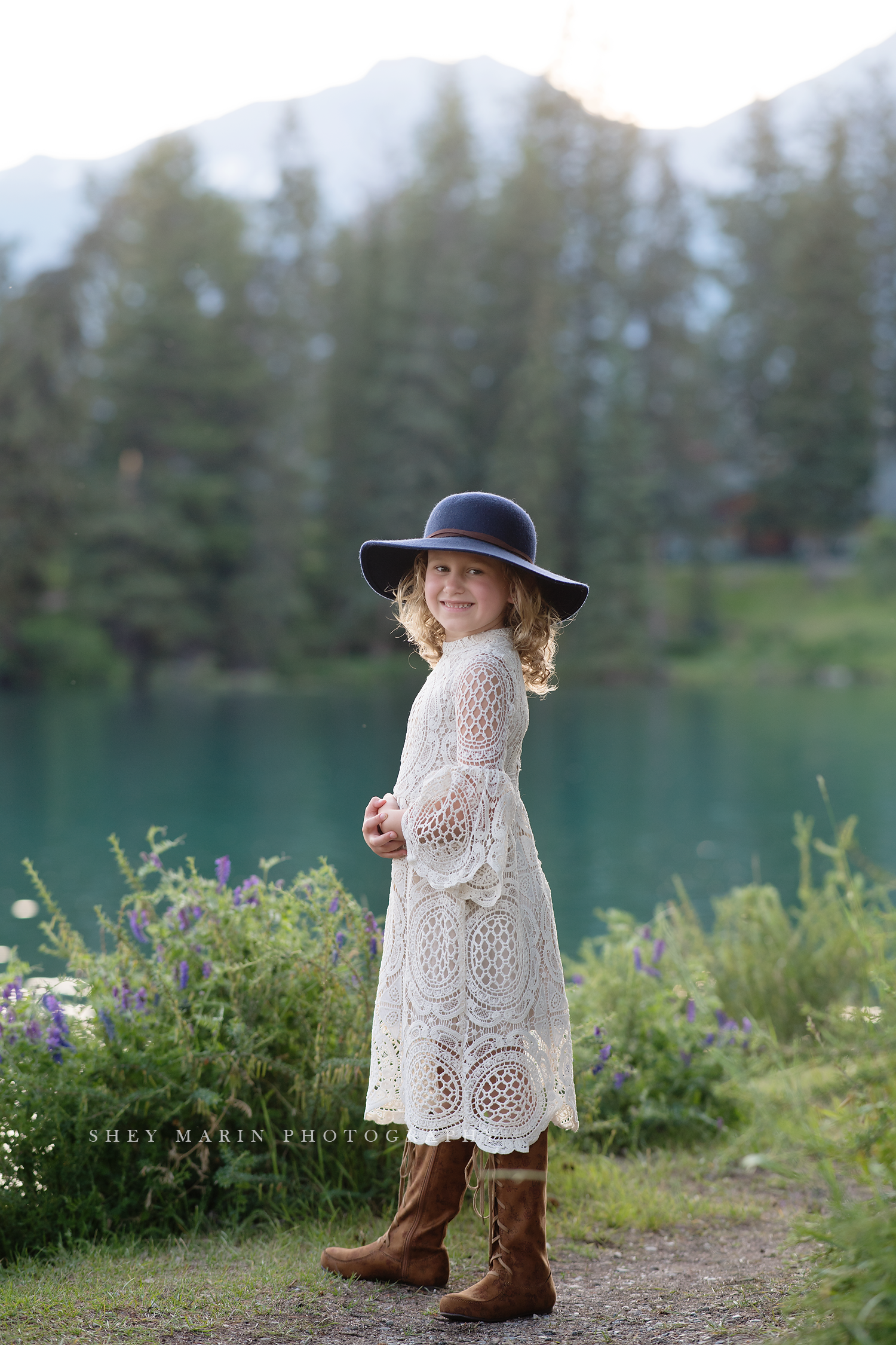 travel family photo session girl in lace dress by lake with hat