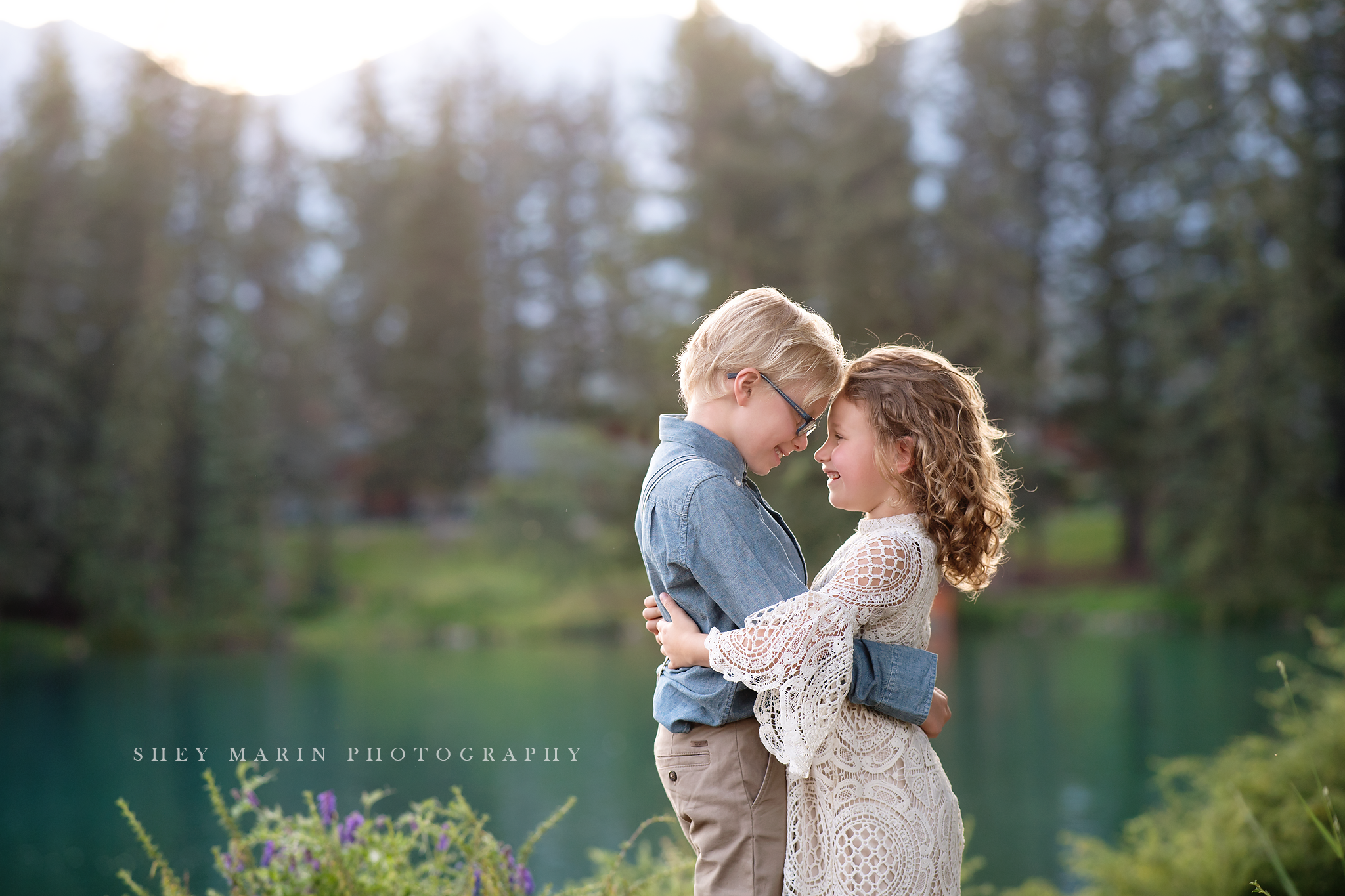 travel family photo session boy by lake and girl hugging