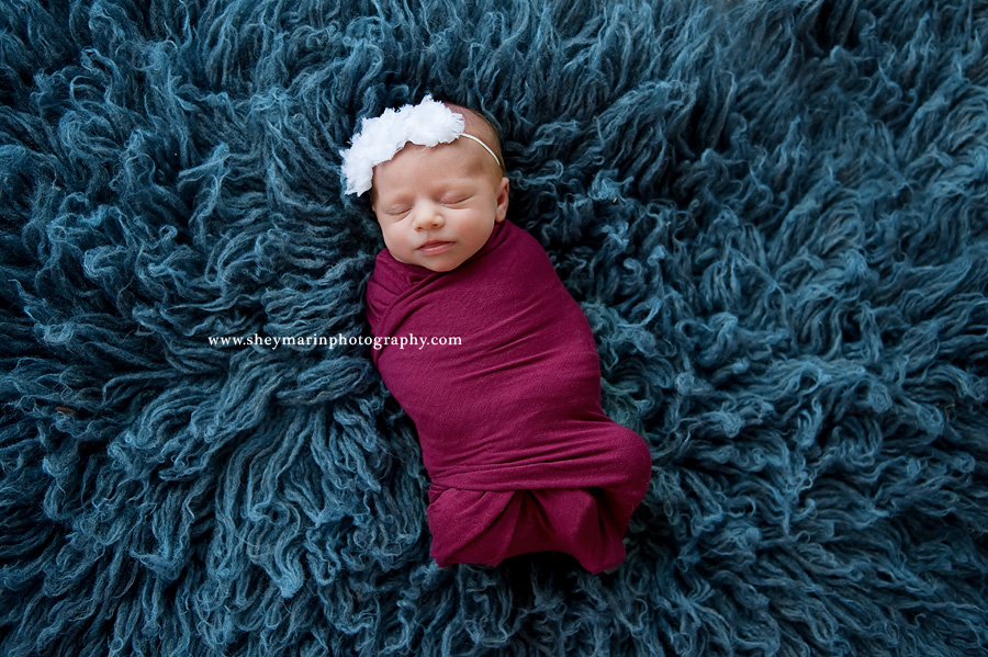 newborn girl with blue fur around her