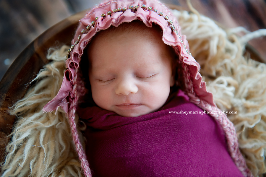 newborn girl in pink bonnet