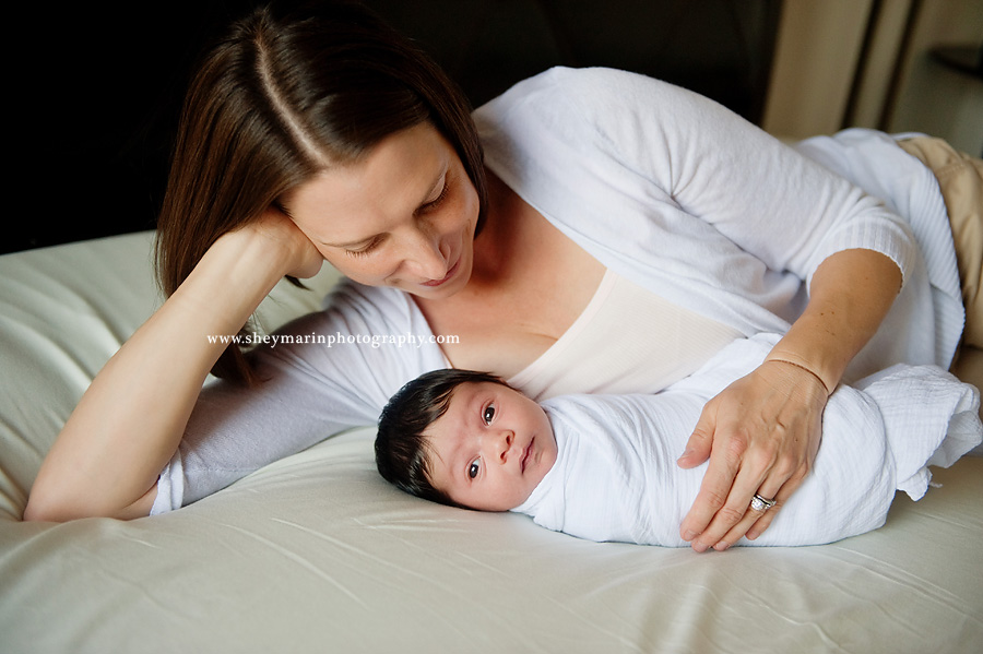 mother lying on bed with newborn