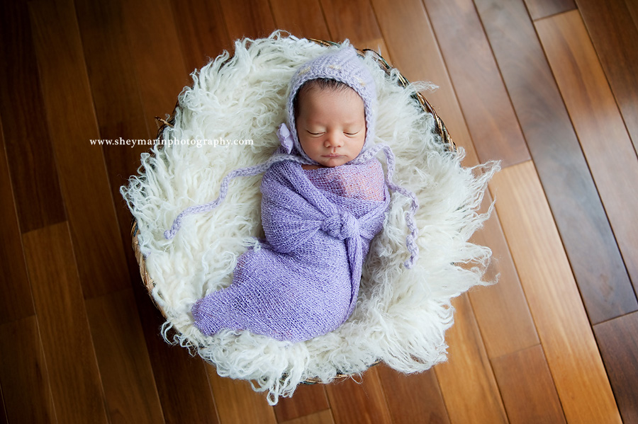 newborn baby girl wrapped in purple