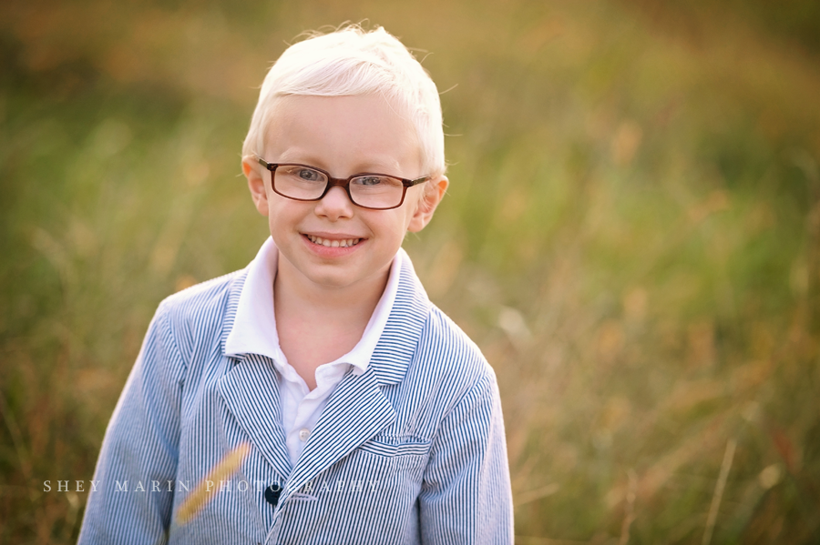 little boy in glasses and seersucker suit