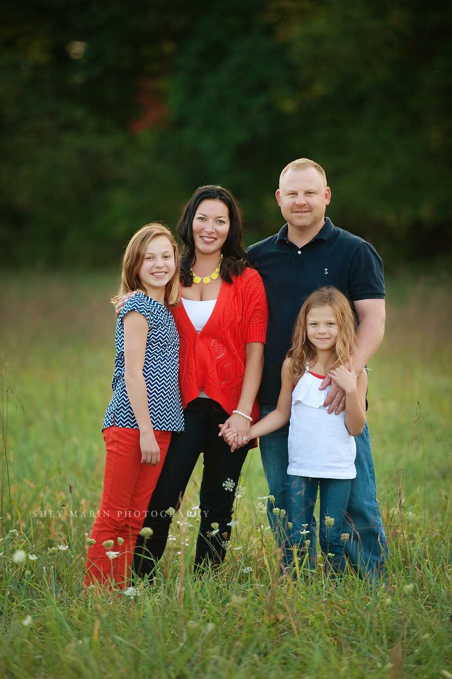 family of four standing in a field