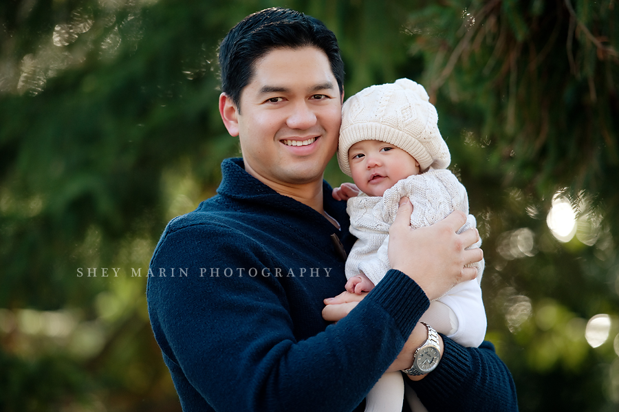 baby girl in winter hat in dad's arms