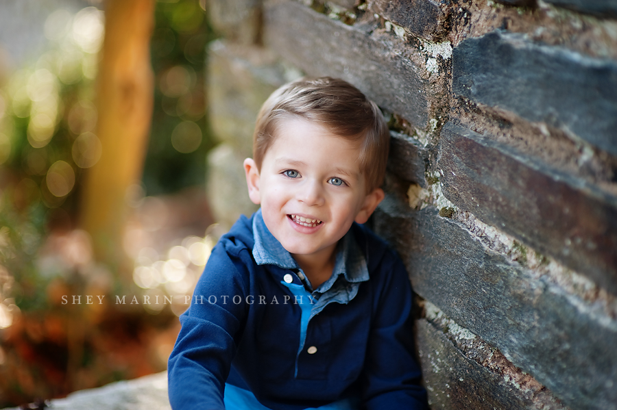 bethesda maryland boy smiling on stone wall