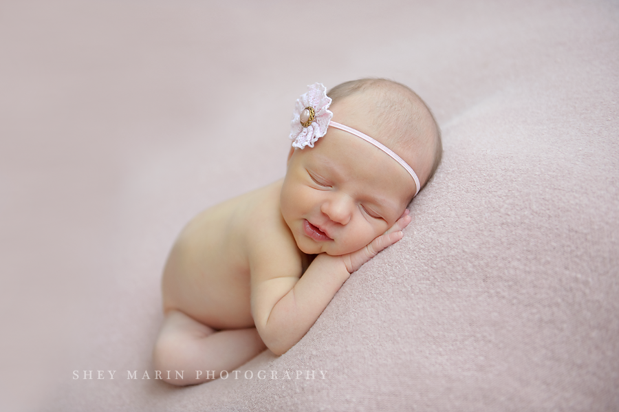 newborn baby girl on pink blanket