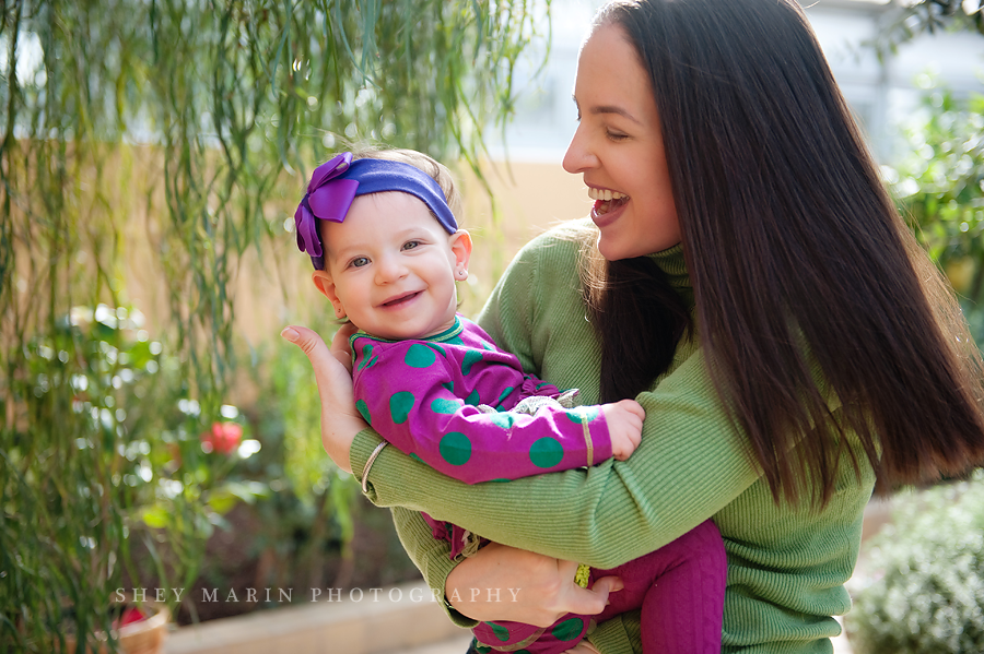 mom and baby swinging in a garden