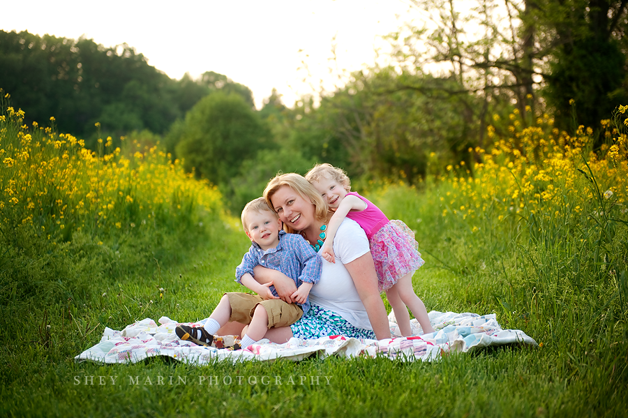 cuddling mom on a blanket in a field