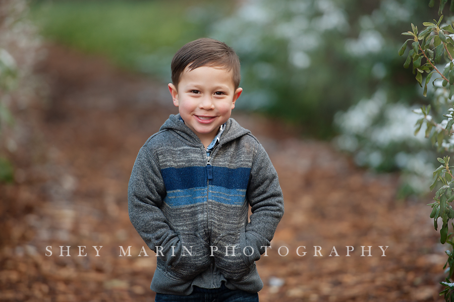 sweet boy in family playing in a winter garden