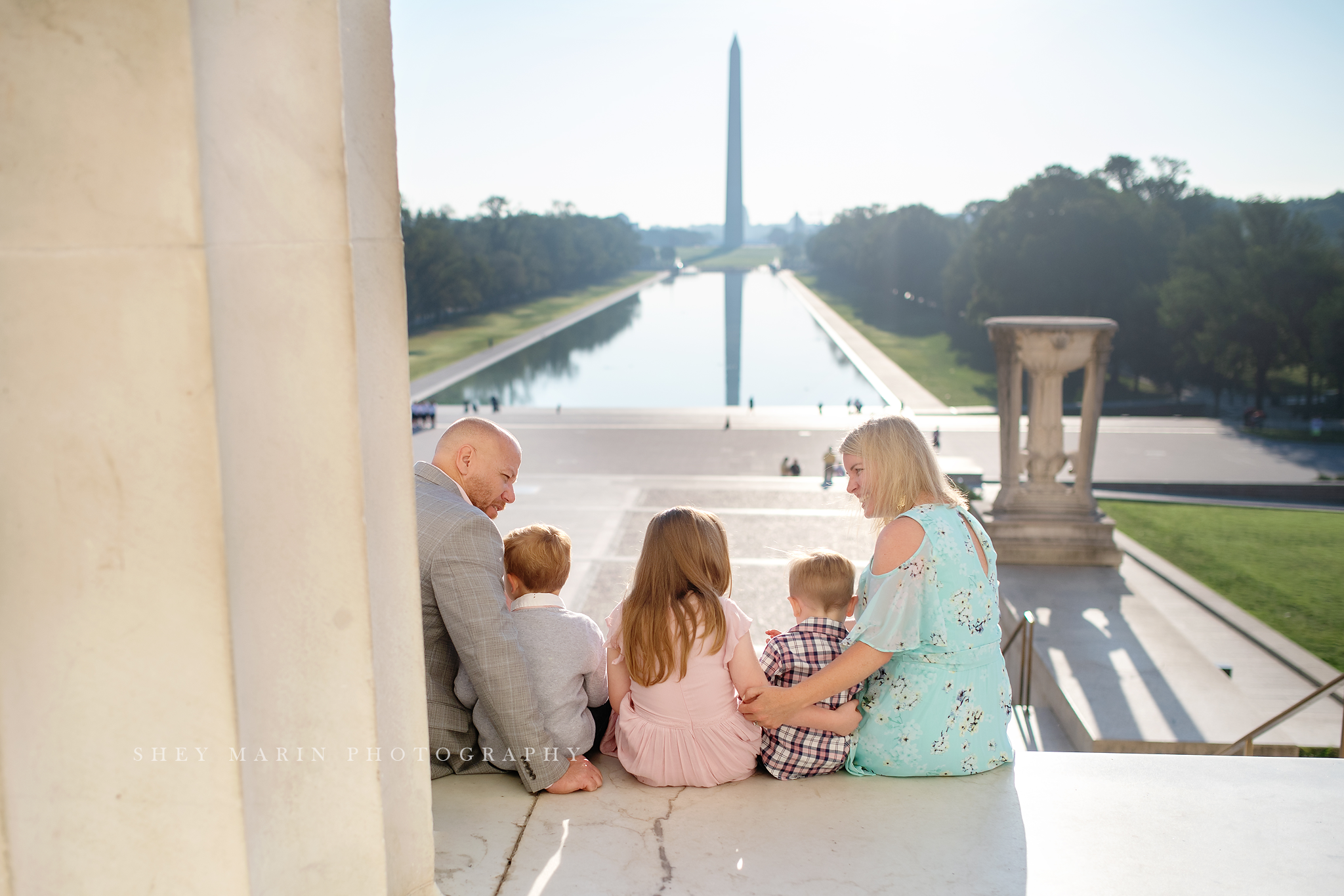 Family sitting on steps of lincoln memorial